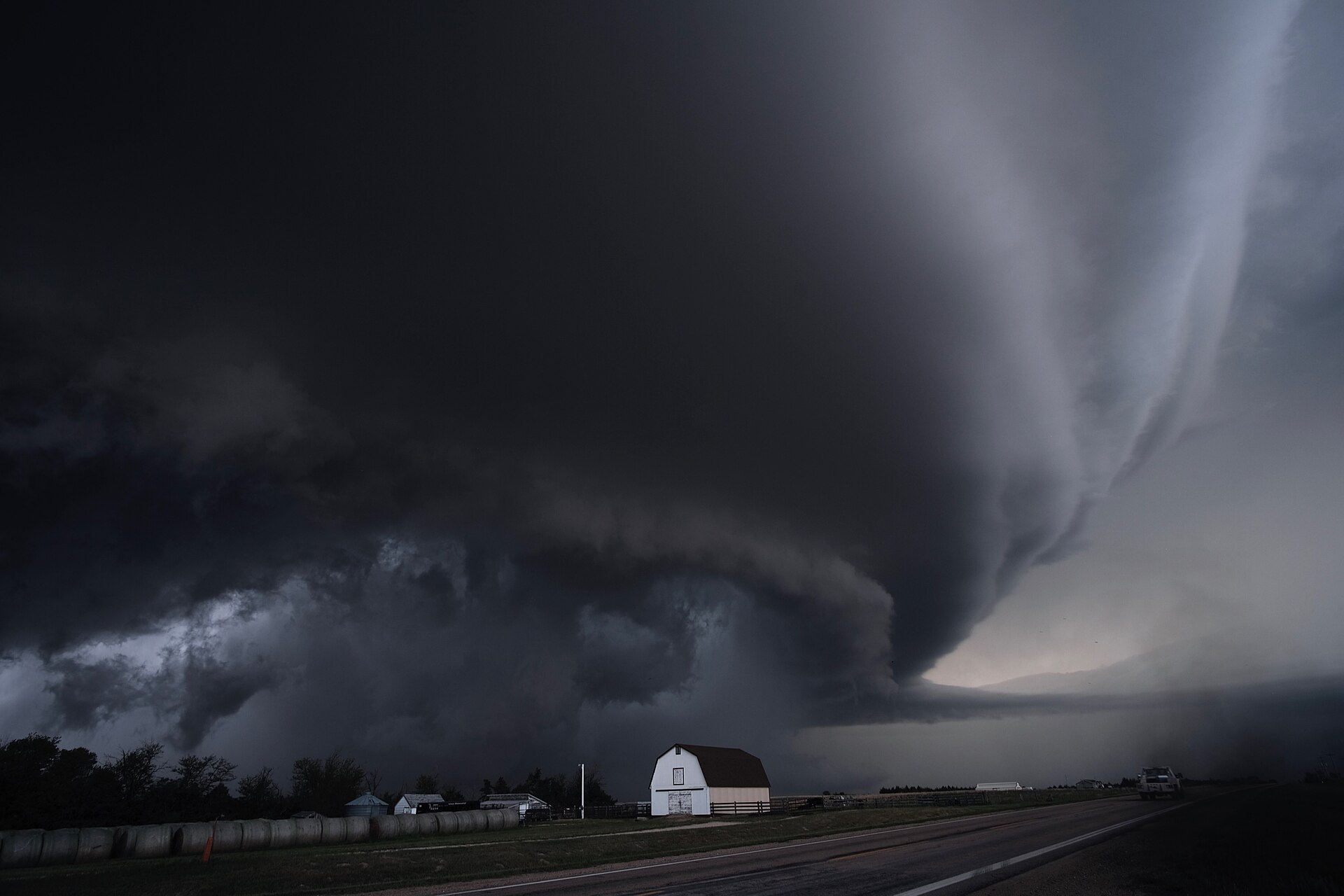 A supercell thunderstorm over a farm and highway in Kansas